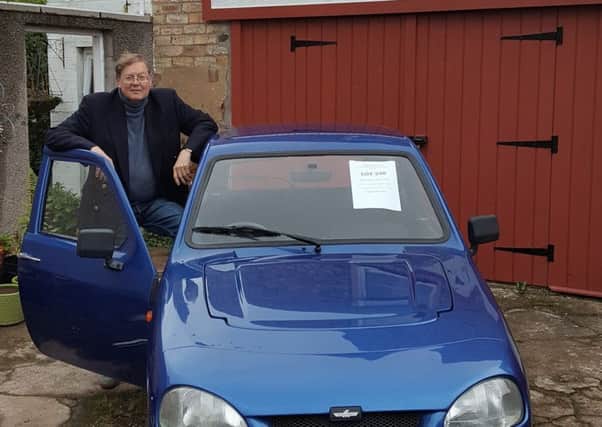 Auctioneer Paul Harris with the reliant robin set to be auctioned off.