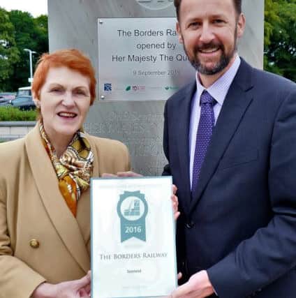Lindley Kirkpatrick of ScotRail being given the Borders Railway's British Guild of Travel Writers award by Vivien Devlin.