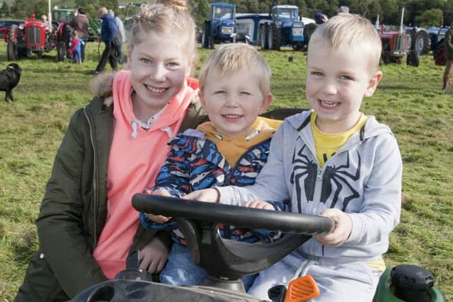 Grace Robson, Ben Cessford and Alexander Huthinson from Yetholm enjoying the vintage tractors at the show.