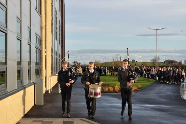 Pipers and a drummer from Kelso Pipe Band lead fellow pupils to the school on its opening day.