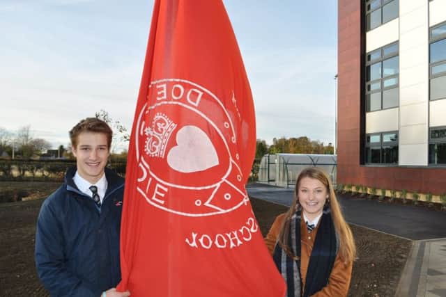 Charlie Graves and Aimee Martin raise the historic Kelso High flag for first time at new school.