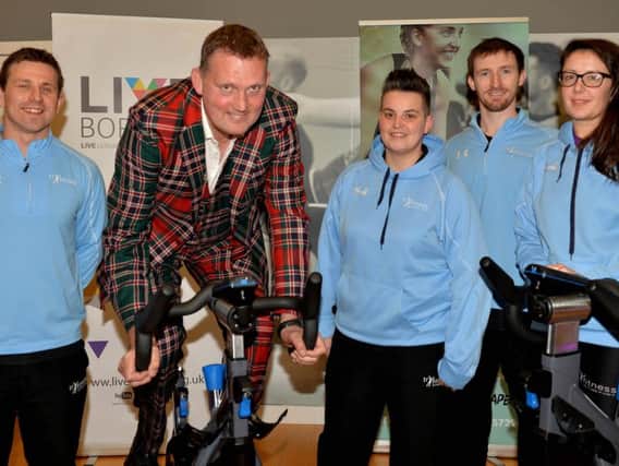 Doddie Weir gets busy with an exercise bike, watched by TriFitness health and fitness advisors Scott Chapman, Sarah Philips, Harry Howland and Suzy Wilson.