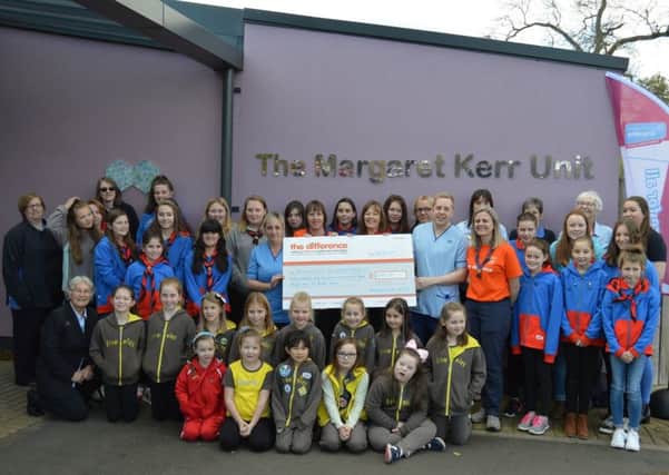 Tweed Valley Guides hand over an Â£8,194 cheque to The Margaret Kerr Unit. They raised the cash via 'Do a mile for Margaret