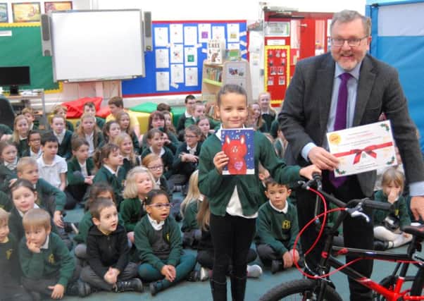 A talented young artist at Halyrude primary school in Peebles has received an early Christmas present after creating the winning design in local MP David Mundells annual Christmas card competition.
Jaymie Donaldson was presented with her bike by Mr Mundell