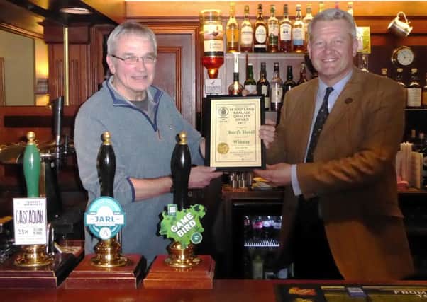 Pat Hanson, chairman of Camra's Edinburgh and south east Scotland branch, presenting a beer quality certificate to Nick Henderson, owner of Burt's Hotel in Melrose.