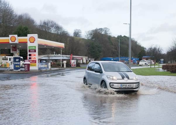 A car travelling through floodwater on the A68 at Jedburgh.