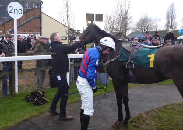 Trainer Stuart Coltherd and jockey Sam untack Achill Road Boy in the Fakenham winners enclosure after Mondays race.