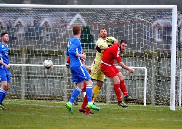 Selkirk, in blue, were in fine goalscoring form recently against Hawick Royal Albert - here, Calum Helm puts pressure on the Royalists' goal (picture by Alwyn Johnston)