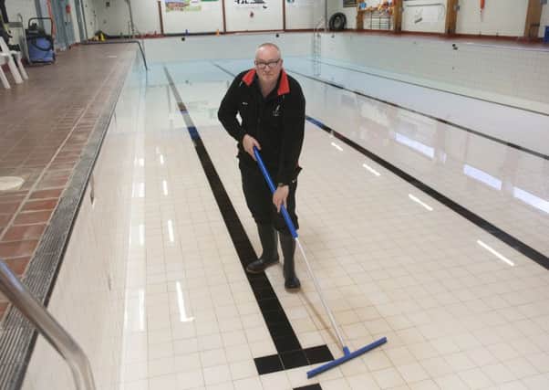 Manager Billy Robson clears glass from Jedburgh's Laidlaw Memorial Pool.