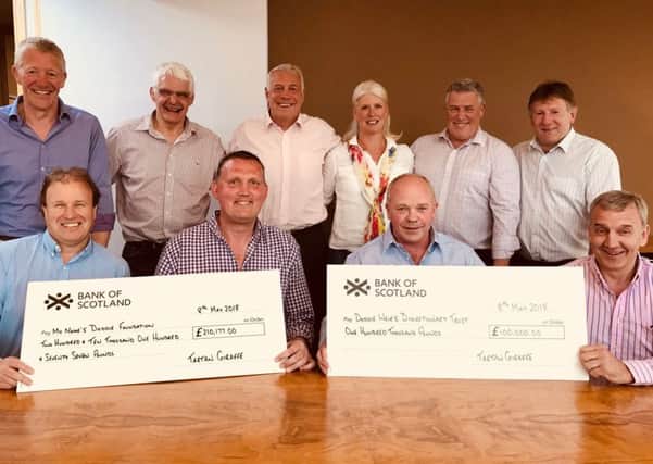 Stewart Bennet, Douglas Stephen and David Baird, the Tartan Giraffe Ball's organisers, hand over cheques worth Â£310,000-plus to Doddie Weir and the My Name'5 Doddie Foundation's trustees.