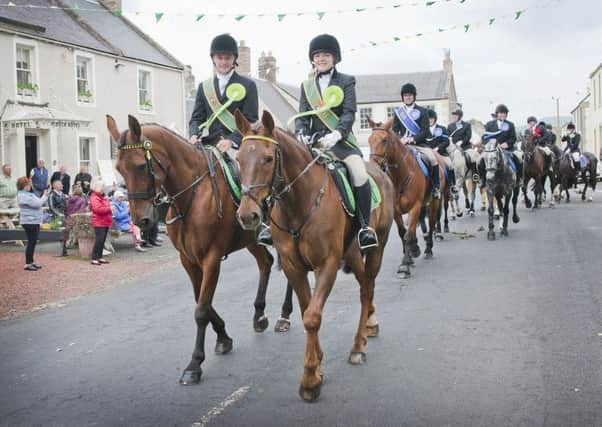 Tom Grindell and Natasha Gray lead the cavalcade out of Yetholm on Wednesday night.