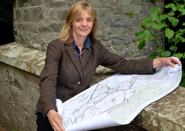 Catherine Maxwell Stuart at Traquair House with a map of the planned paths.