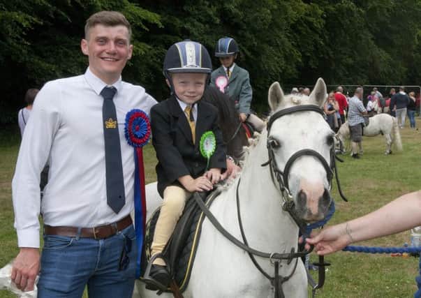 Jake Grant and Max receive their rosette at the leading rein ride from Callant Arnold.