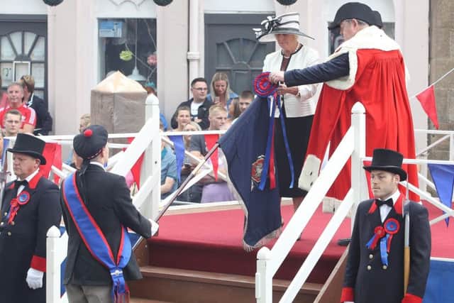 Honorary provost Harvey Oliver gives wife Helen a helping hand to buss the flag on Friday morning.