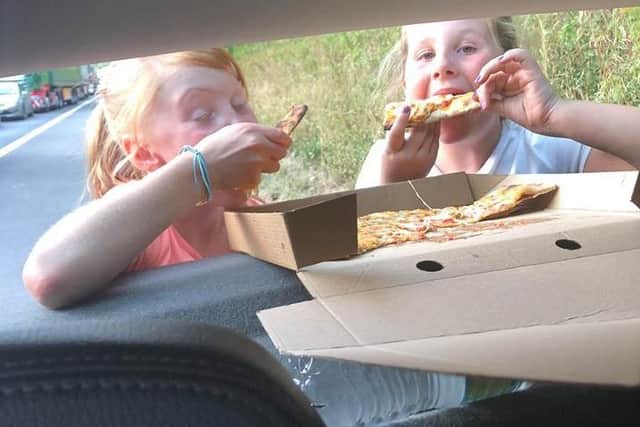 Miah and Rhea-Marie get stuck into the pizza thanks to local resident Jenna.