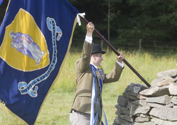 Cornet Chris Rogerson offloads the flag as the cavalcade stops for a rest and sing song at the waterin' stane.