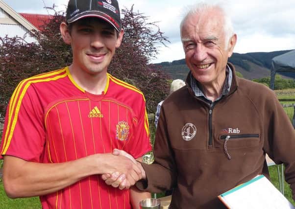 Thomas Bryson, left, collects his prize from sports committee chairman Donald Macleod (picture by John Smail).