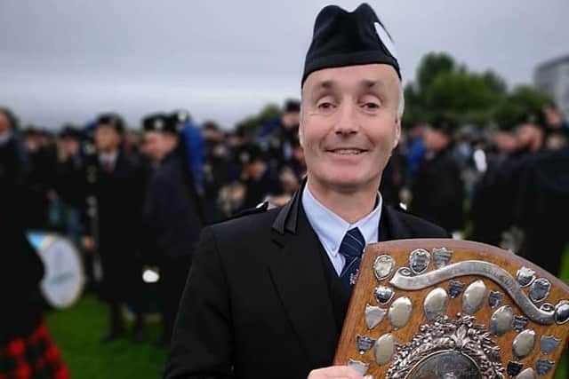 Pipe Major Bruce Gillies with the trophy.