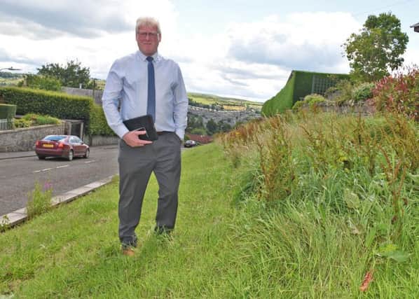 Councillor Stuart Marshall on an overgrown embankment in Hawick.