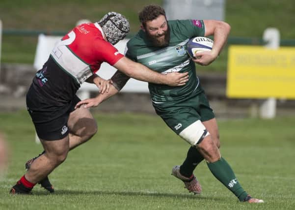 Former Hawick captain Bruce McNeil evades a Hawks tackle.