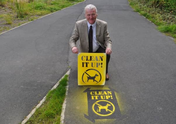 SBC councillor David Paterson with the new stencil  promoting Scottish Borders Councils dog fouling message on pavements and paths across the region.