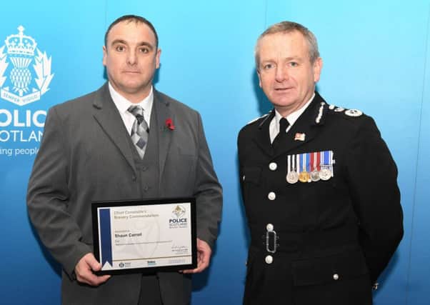 Jedburgh's Shaun Carroll receives his bravery award from Chief Constable Iain Livingstone.