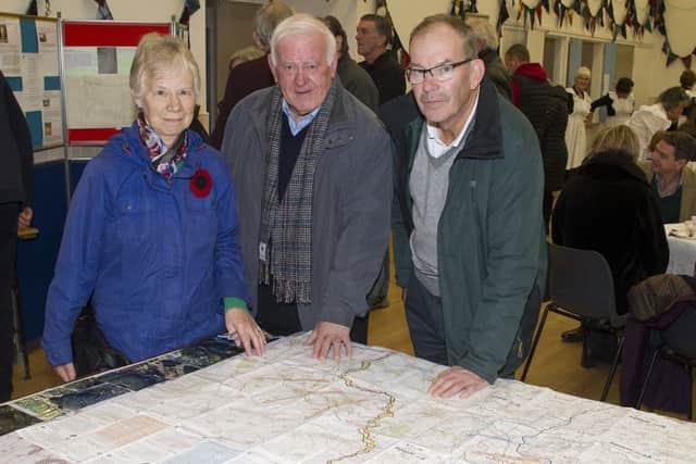 Muriel and Jim Wilson with David Howden study a map of Battles throughout Belgium at a display in Denholm's Village Hall.