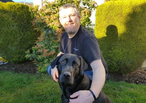 John Davidson of Galashiels, pictured with his dog Suki, has been awarded the MBE for services to sufferers of Tourette's syndrome.