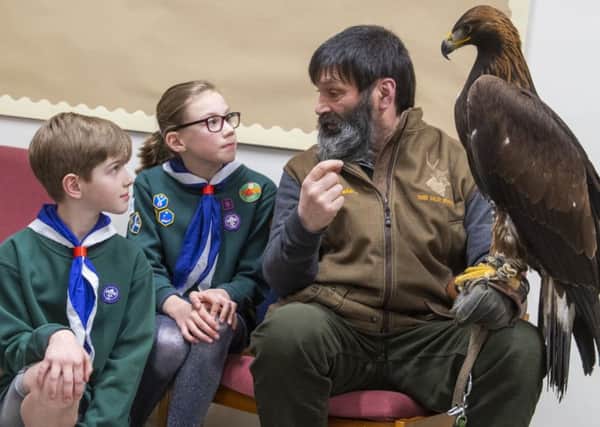 Handler Douggie McKenna holds Kasia the golden eagle as cubs Moya McLaughlin and Innes Reilly look on.