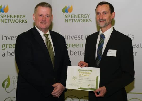 Hawick community councillor Andy Maybury, right, being given £107,000 by SP Energy Networks chief executive officer Frank Mitchell in Glasgow last November to help get the town's electric car club started.