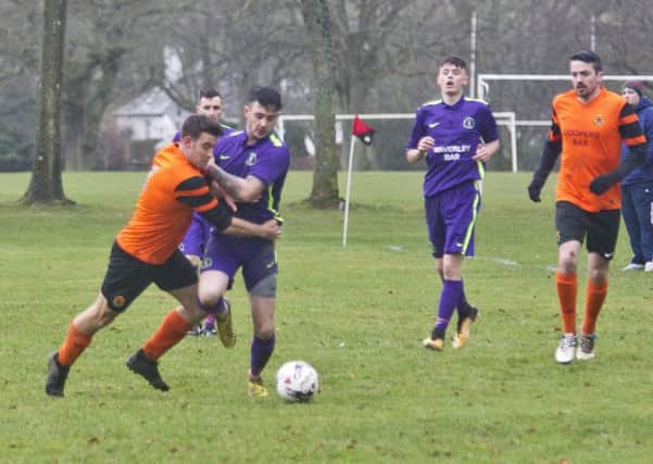Dean McColm, for Hawick Waverley (in purple) fends off a challenge from Luke Shanley for Hawick United in another explosive derby (pictued by Bill McBurnie)