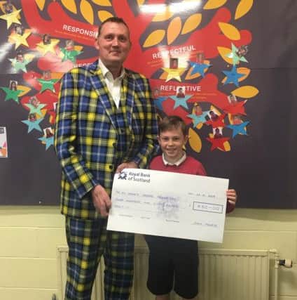 Jack Fourie hands over the cash he raised to Doddie Weir.