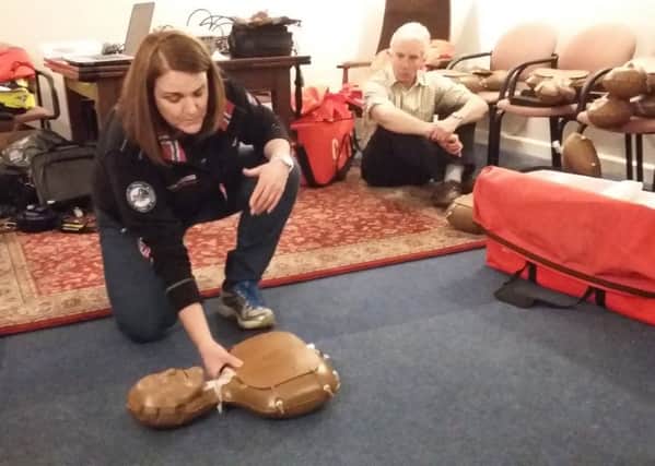 A member of the Tweed Valley Mountain Rescue Team  sets up a CPR dummy to demonstrate to the Earlston Resilience Team..
