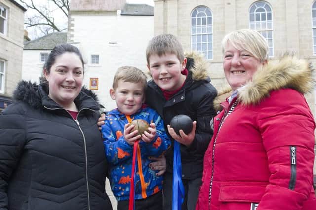 Beckie and Zach Anderson with Aidan Smith and Nanny Lesley Porterfield throwing the ball up in memory of her dad, Alan Porterfield.