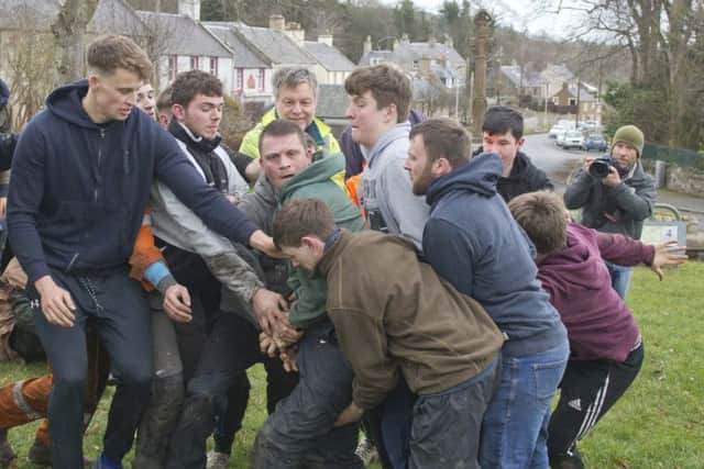 Robbie Elder, Craig Cowan and Craig Goodfellow grapple for the ba' at Ancrum.