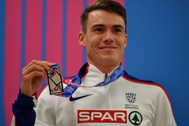 Men's 3000m finalist Chris O'Hare with his silver medal on the rotrum (photograph by BEN STANSALL/AFP/Getty Images)