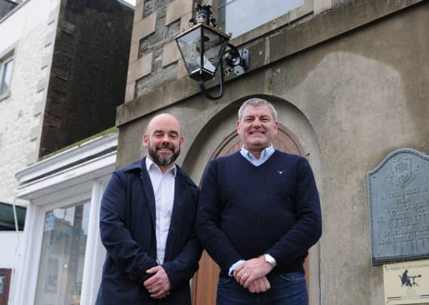 Stuart Davidson and David Heard with the restored lamp above the Town Hall front door.