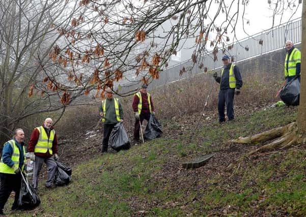 The group of volunteers who look after the gardens of Old Gala House pick litter along the steep banking at Huddersfield Street in Galashiels.