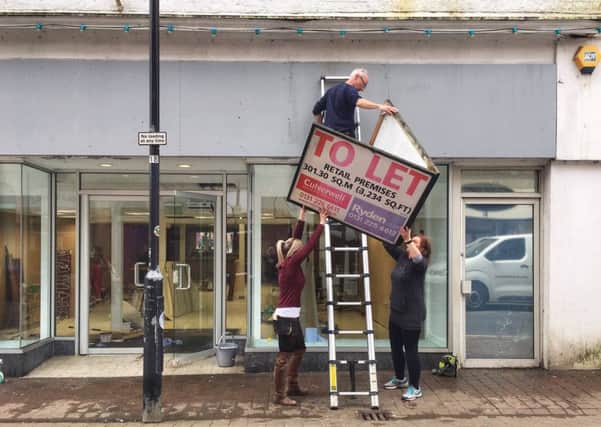 Whynot? directors Kashana Elder, Adam Elder and Jenny Potter removing a to-let sign at its new premises at 50 Channel Street in Galashiels.