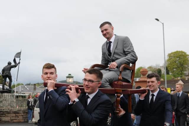 Craig Monks is hoisted into the Victoria Halls on Friday evening by his attendants.