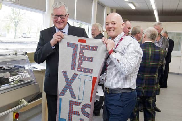 Fergus Ewing, Scotland's rural economy secretary, with Alistair Young, manager of Hawick's new textile training centre.