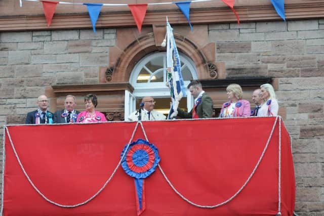 Honorary Provost Keith Miller hands the flag to Craig Monks with the proviso it is returned to him unsullied and untarnished.