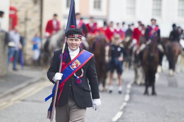 Callant Euan Munro carries the flag to the platform.
