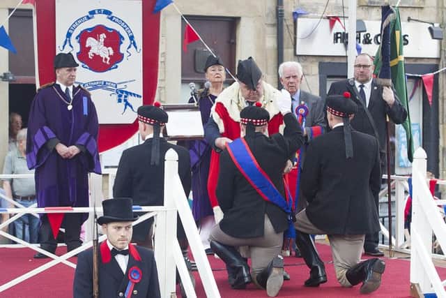 Callant Euan Munro and his henchmen receive their sashes and the Jethart flag and axes during the investiture ceremony.