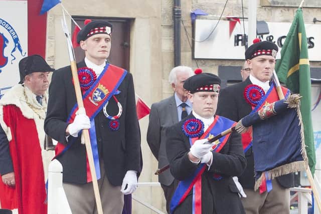 Callant Euan Munro and his henchmen receive their sashes and the Jethart flag and axes during the investiture ceremony.