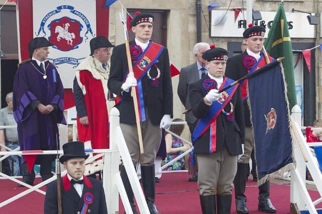 Callant Euan Munro and his henchmen receive their sashes and the Jethart flag and axes during the investiture ceremony.