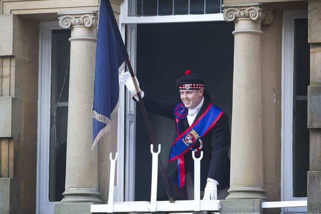 Callant Euan Munro displays the flag from the town hall.