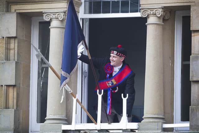 Right-hand man Nick Arnold waves to the crowd from the town hall.