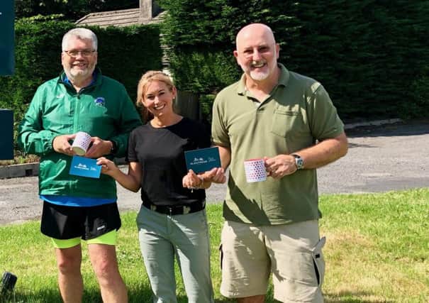 Scottish Borders Hill Race Weekend organisers Gerry Moss and Gregor Nicholson receive vouchers and polka-dot mugs for the King and Queen of the Borders Hills from Alex Nisbet of the Glentress Hotel.