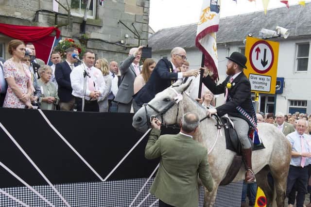 Cornet Henry Jeffrey receives the flag from officiating magistrate Roger Maxwell.